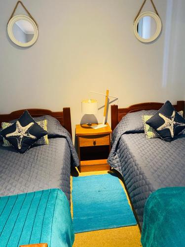a bedroom with two beds and a table with a lamp at Departamento La Serena Avenida Del Mar in La Serena