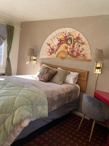 a bedroom with a bed with a painting on the wall at Monte Bianco Inn in Mount Shasta