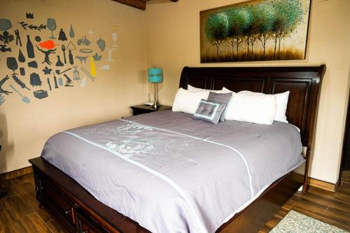 a bedroom with a large bed with a painting on the wall at Quinta Monasterio in Valle de Guadalupe