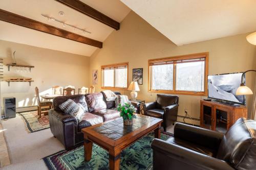 a living room with leather furniture and a table at Breakaway West - Studio, 2,3 Bedrooms by Vail Realty in Vail