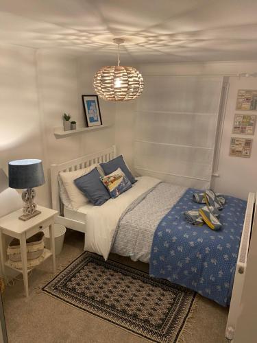 a bedroom with a bed and a table and a lamp at Centrally located, comfortable apartment near Station, Beach and North Laines in Brighton & Hove