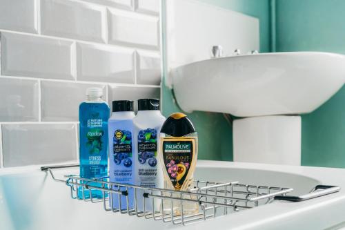 a bathroom sink with bottles of cleaning products on it at Skelton house - Short stay leeds in Leeds