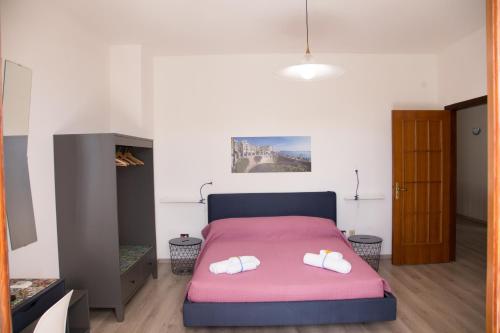 a bedroom with a pink bed with white shoes on it at VILLA VEGA in Fontane Bianche