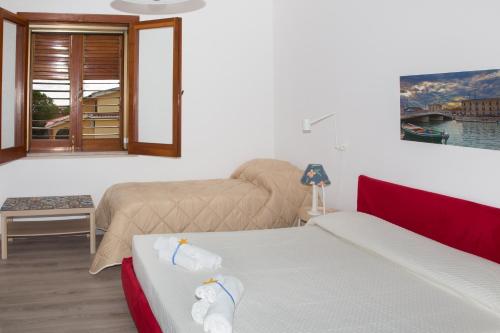 a hotel room with two beds and a window at VILLA VEGA in Fontane Bianche