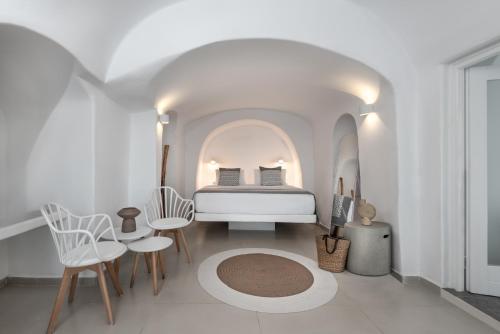فيلات كالديرا بريميوم في أويا: غرفة نوم بسرير في غرفة بيضاء