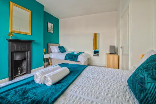 a bedroom with two beds and a fireplace at Skelton house - shortstayleeds in Leeds
