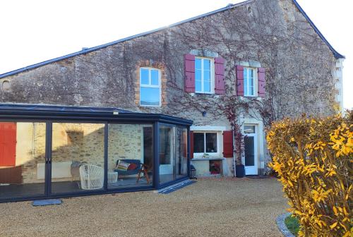 a house with colorful windows and a yard at L'Aubinoise in Saint-Aubin-de-Luigné