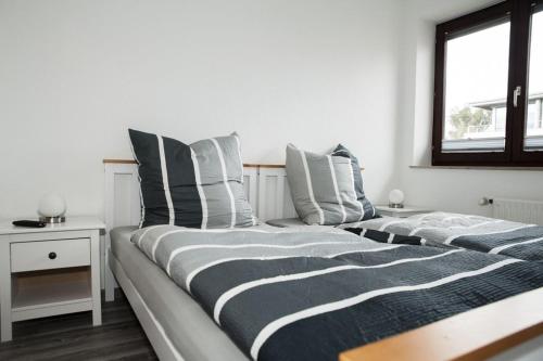 a bedroom with two beds with striped pillows and a window at EXKLUSIVE Ferienwohnung mit Balkon, 2 Schlafzimmer im HAUS SERTÜRNER in Einbeck