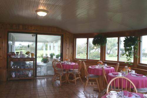 a dining room with pink tables and chairs at Rose Farm Inn in New Shoreham