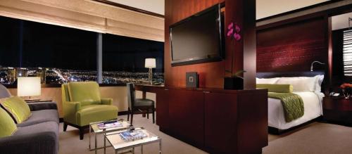 a hotel room with a bed and a flat screen tv at Jet Luxury at The Vdara in Las Vegas