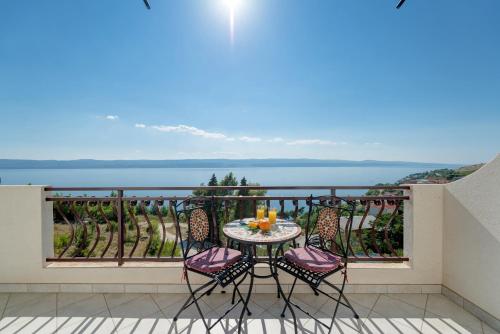 a table and chairs on a balcony with a view of the water at Luxury Apartments Tafra in Lokva Rogoznica