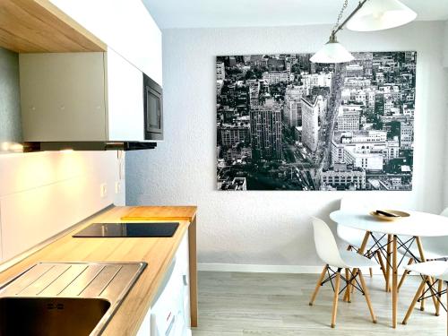 a kitchen with a table and a painting on the wall at Málaga Beach and Historic centre Malagueta in Málaga