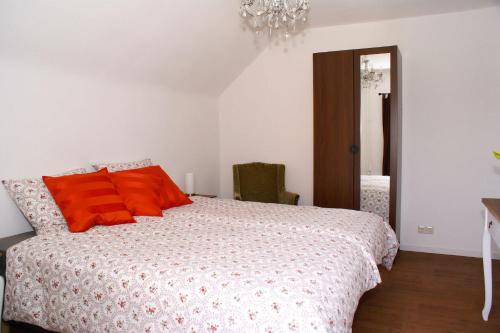 een slaapkamer met een bed met oranje kussens erop bij Bed and Breakfast de Meule Montfort in Montfort