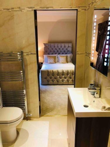 a bathroom with a bed and a toilet and a sink at Beautiful 4-Bed Villa in Glasgow in Glasgow