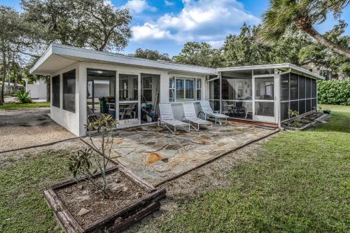 een huis met een afgeschermde veranda en stoelen in de tuin bij Lemon Bay Escapade in Englewood