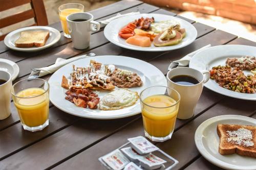 a table with plates of breakfast foods and orange juice at Quinta Monasterio in Valle de Guadalupe