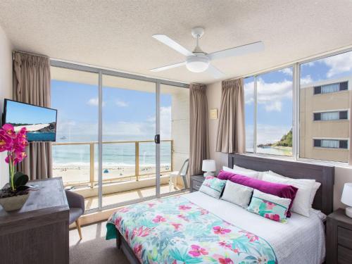a bedroom with a bed with a view of the beach at Ebbtide 22 in Forster