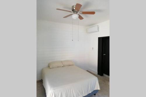 a bedroom with a ceiling fan and a bed at Maruchita's room in Bacalar