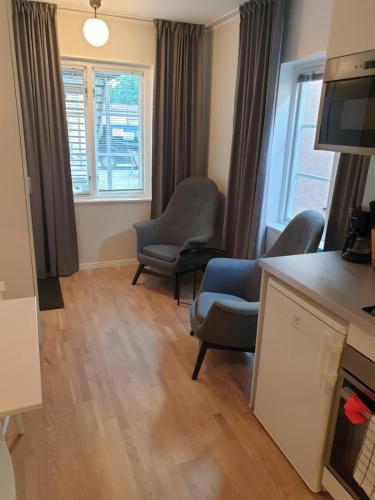 een woonkamer met 2 stoelen en een televisie bij Adelsgatan 36 lägenhetshotell, Gotland Living and Meeting in Visby