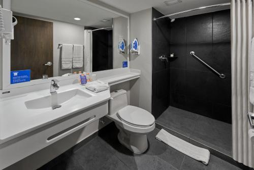 ein Bad mit einem Waschbecken, einem WC und einer Dusche in der Unterkunft City Express by Marriott Caborca in Heroica Caborca