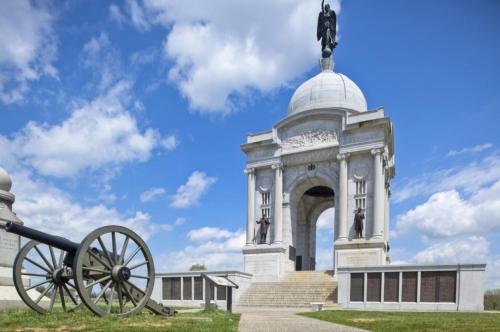 a monument with a cannon in front of a building at Holiday Inn Express & Suites - Gettysburg by IHG in Gettysburg