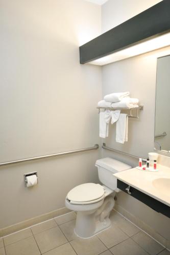 a bathroom with a toilet and a sink at Days Inn & Suites by Wyndham Airport Albuquerque in Albuquerque