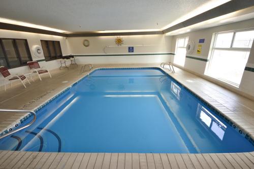 a swimming pool with blue water in a building at Days Inn & Suites by Wyndham Airport Albuquerque in Albuquerque
