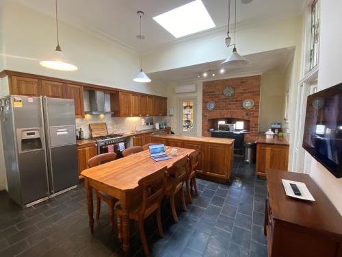 a kitchen with a table and a refrigerator at Bon Accord in Sale