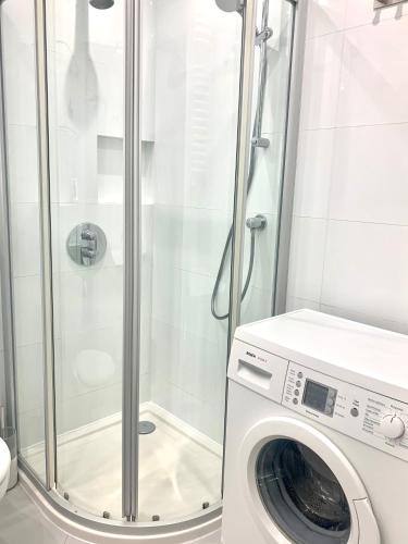 a washing machine in a bathroom with a shower at Sopocka Bryza in Sopot