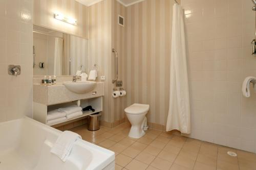 a bathroom with a sink and a toilet and a shower at Wairakei Resort Taupo in Taupo
