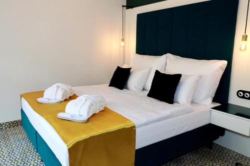 a large bed with white towels on top of it at Art Deco WOLKER by ASTORIA Hotel & Medical Spa in Karlovy Vary