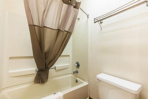 a bathroom with a toilet and a shower curtain at Motel 6-Covington, TN in Covington