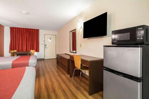 a hotel room with a bed and a desk with a computer at Motel 6-Covington, TN in Covington