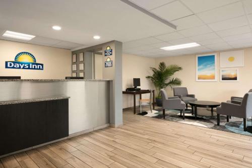 an office lobby with a waiting area with tables and chairs at Days Inn by Wyndham Clearwater/Central in Clearwater