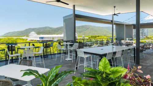 a large outdoor dining area with tables, chairs and umbrellas at Oaks Cairns Hotel in Cairns