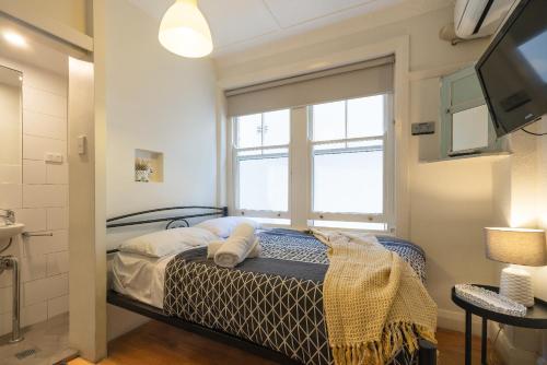 1 dormitorio con cama y ventana en Highfield Private Hotel, en Sídney