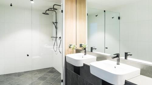 
a bathroom with two sinks and a mirror at Oaks Cairns Hotel in Cairns
