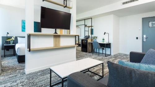 a living room with a flat screen tv on a wall at Oaks Cairns Hotel in Cairns