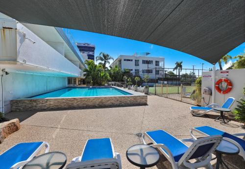 a swimming pool with lounge chairs and a swimming pool at Elouera Tower in Maroochydore