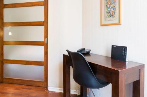 a black chair sitting at a wooden desk at Departamentos Pontoni (Bellas Artes) in Santiago