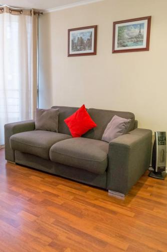 a couch with two pillows on it in a living room at Departamentos Pontoni (Bellas Artes) in Santiago