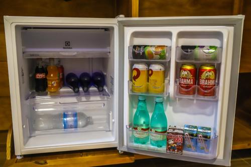 an open refrigerator filled with drinks and drinks at POUSADA JURERE DA CANASTRA in Vargem Bonita