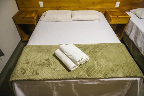 a bed with two towels sitting on top of it at POUSADA JURERE DA CANASTRA in Vargem Bonita