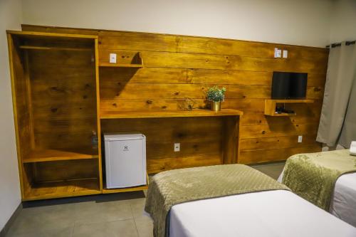 - une chambre avec 2 lits et un mur en bois dans l'établissement POUSADA JURERE DA CANASTRA, à Vargem Bonita
