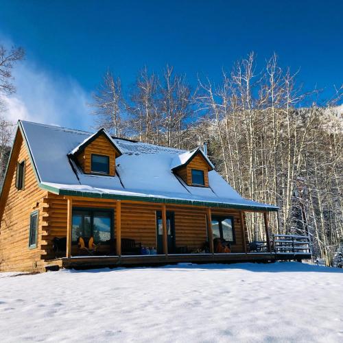 a log cabin with snow on the roof at Beyul Retreat in Meredith