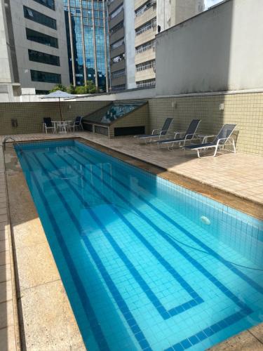 a large blue swimming pool on top of a building at Flat Pancetti in Belo Horizonte