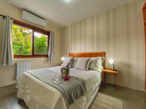 a bedroom with a bed with glasses on it at Pousada Flor De Canela in Canela