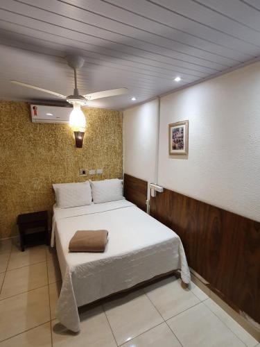 a bedroom with a large bed with a ceiling at Hotel Talu in Angatuba