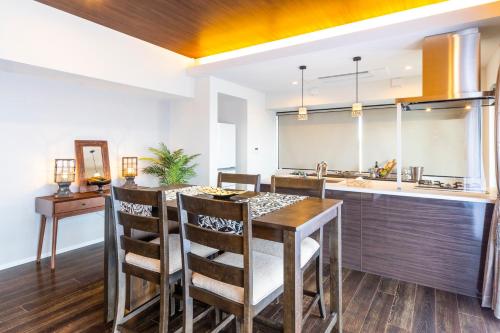 a kitchen with a wooden table and chairs and a sink at Rizo Zaizen Hotel in Ginowan