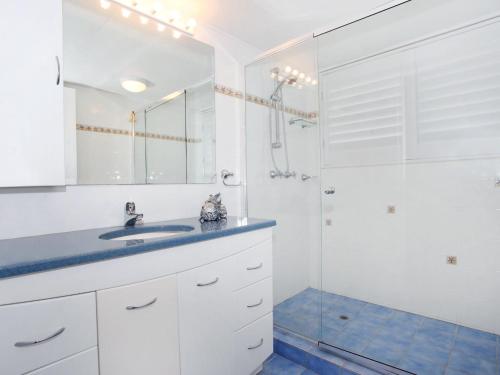 a white bathroom with a sink and a shower at Courtney Cove 1 Comfortable Two Bedroom Apartment on Mooloolaba Canal in Mooloolaba